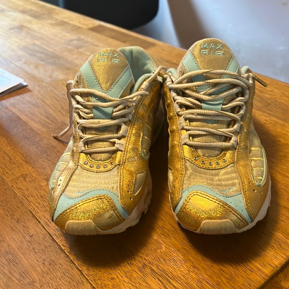 Woman's like new Nike sneakers. Primarily gold with baby blue in areas.